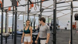 Man and woman exercising at an indoor gym, focused on fitness goals.